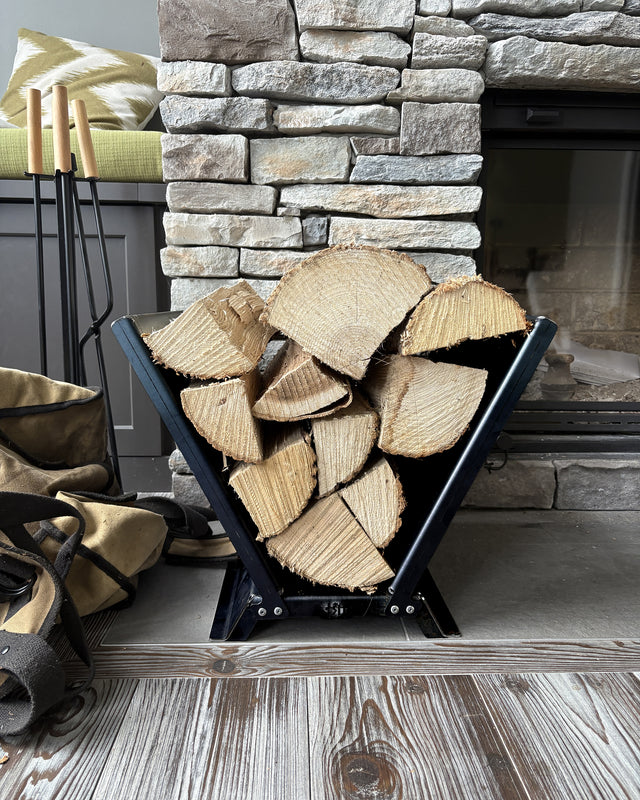 Modern V-shaped firewood rack in matte black steel, designed for indoor and outdoor log storage holder by The Rack Co.