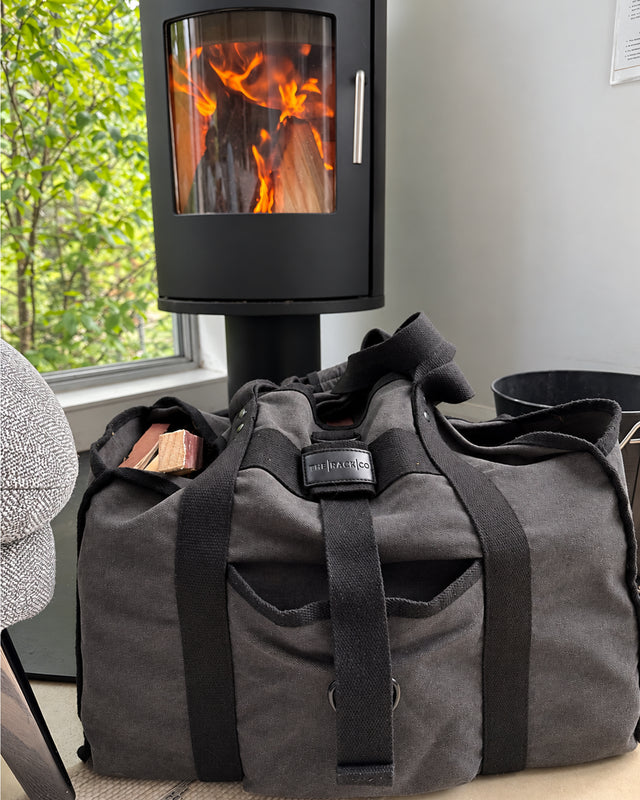 charcoal.jpeg
Charcoal waxed canvas firewood carrier filled with logs beside a wood-burning stove