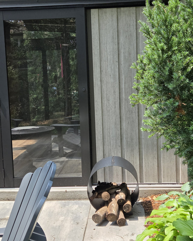Circular steel firewood rack used outdoors for firewood storage